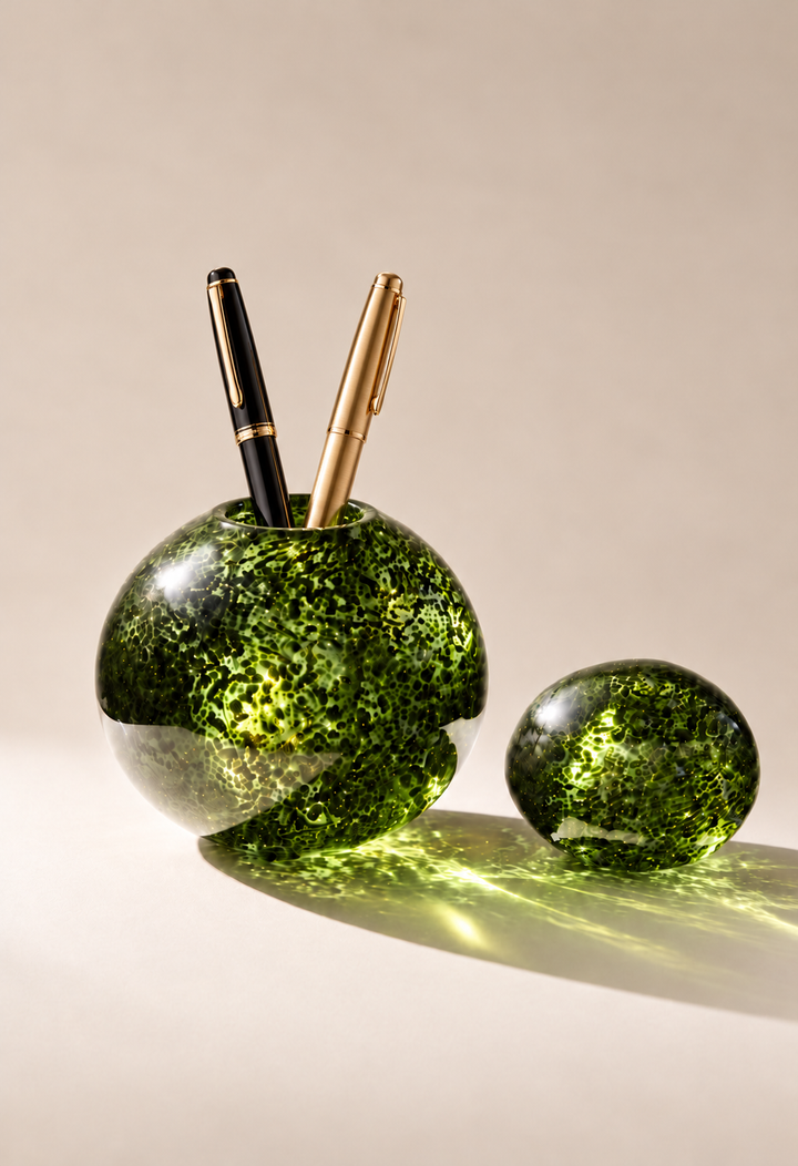 Shimmering Moss COCOON® holding two pens in a warm ivory studio