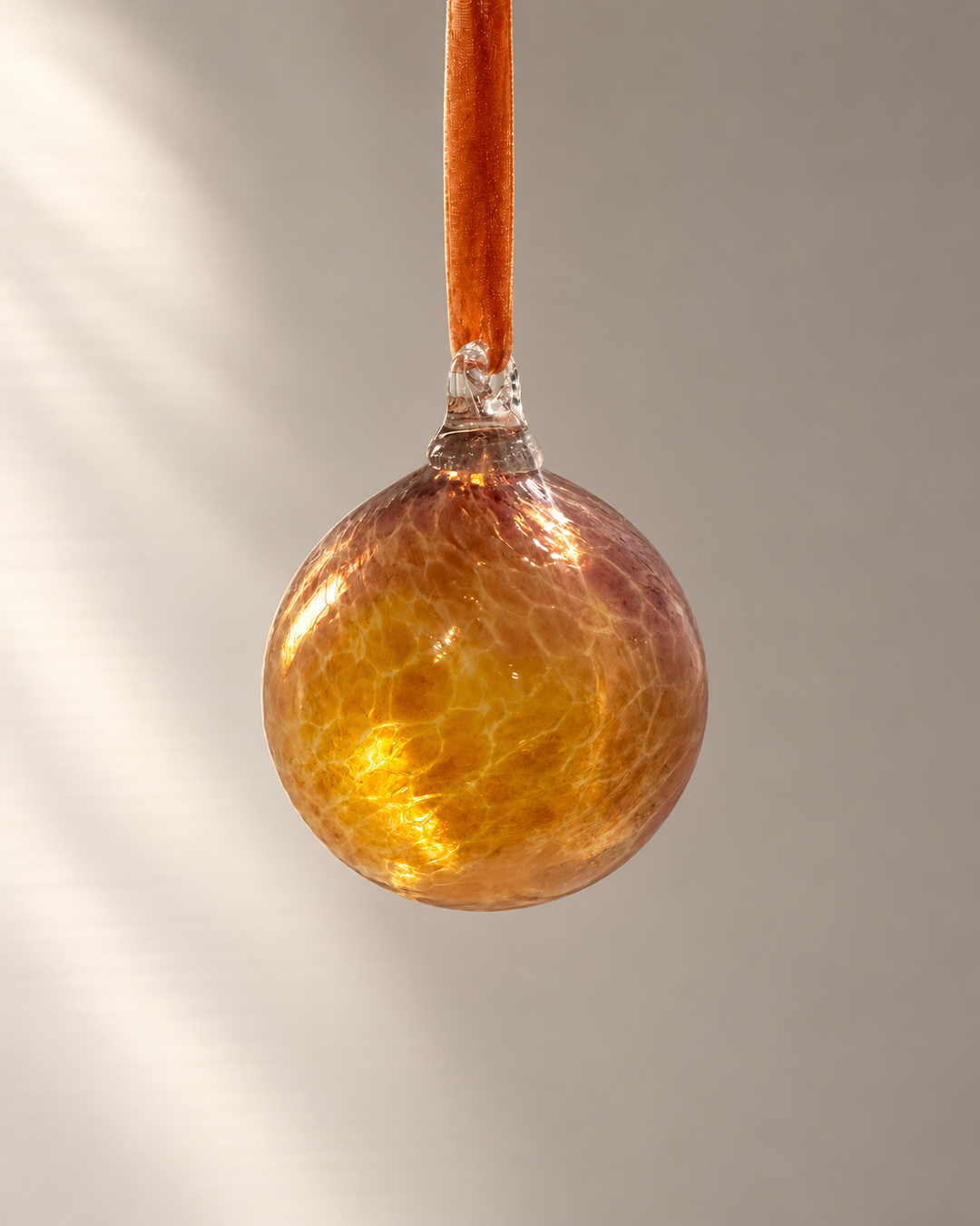 Amber Smoke Glass Bauble hanging from a velvet ribbon