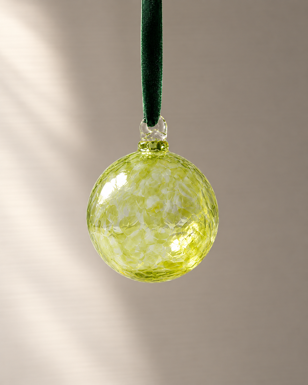 Citrine Lime Glass Bauble hanging from a velvet ribbon