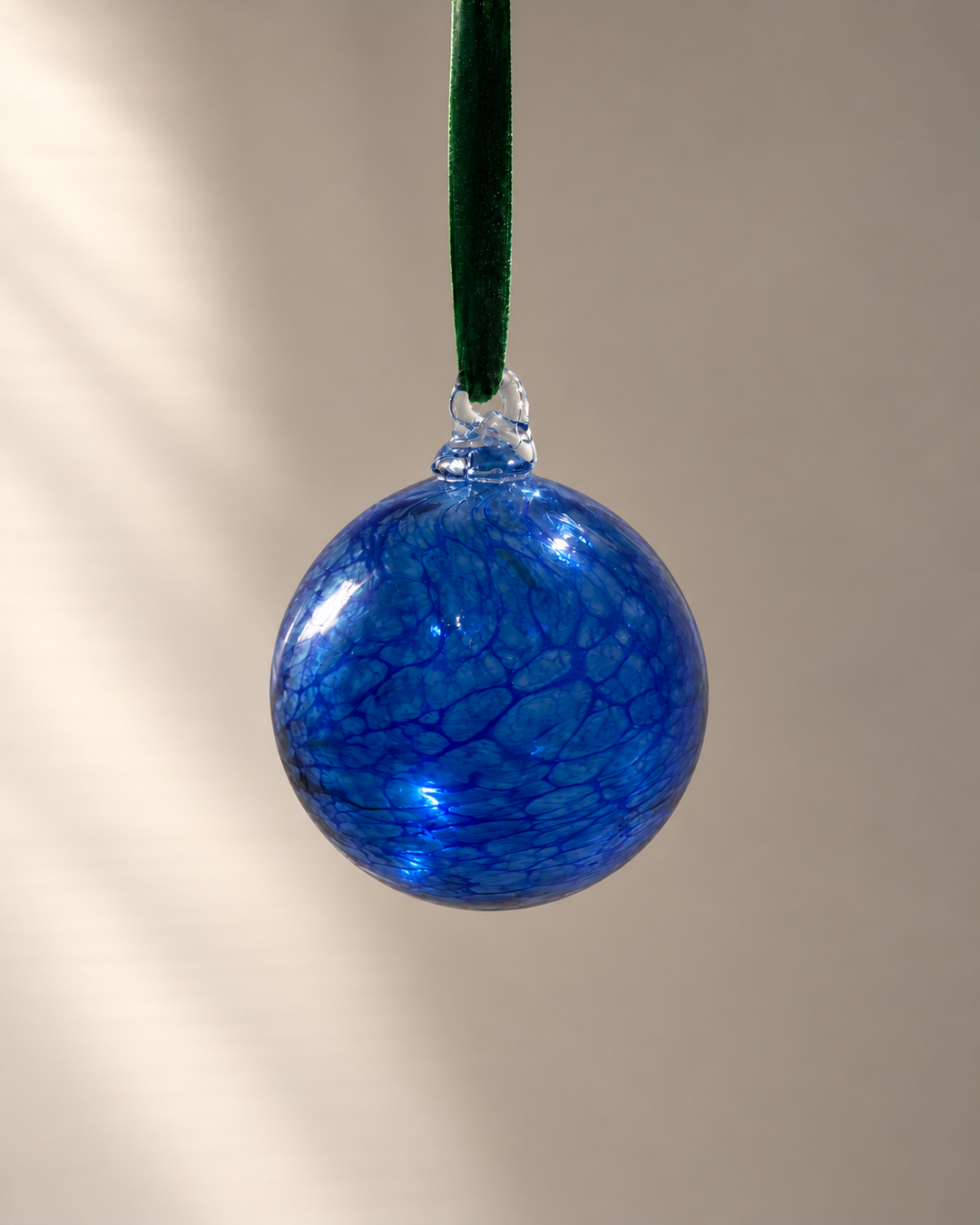 Cobalt Blue Glass Bauble hanging from a velvet ribbon