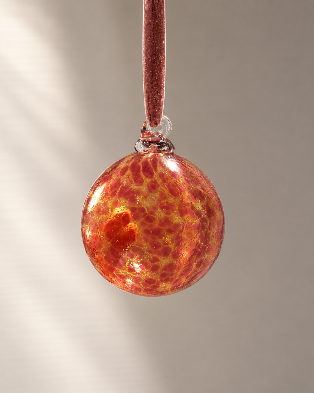 Coral & Gold Glass Bauble hanging from a velvet ribbon