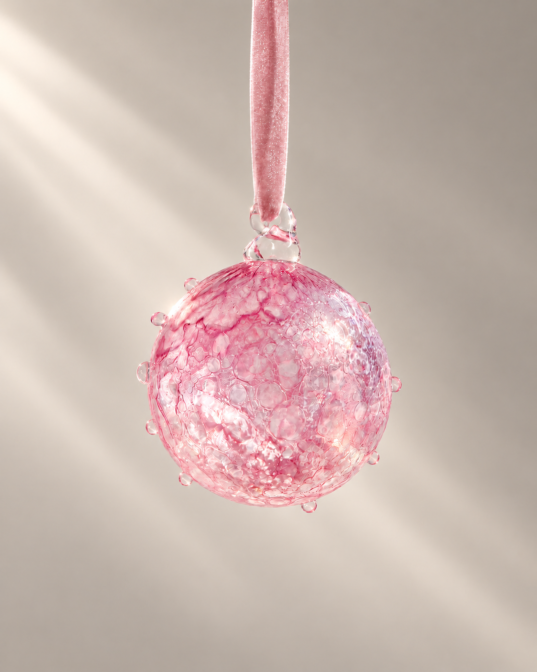 Pink Lagoon Glass Bauble hanging from a velvet ribbon