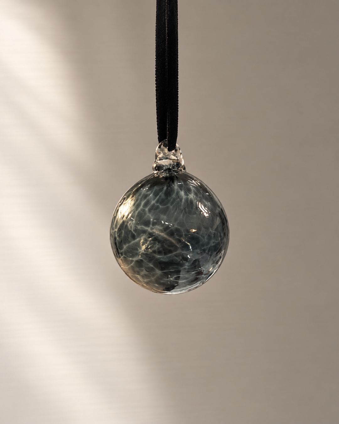 Miniature Charcoal Glass Bauble hanging from a velvet ribbon