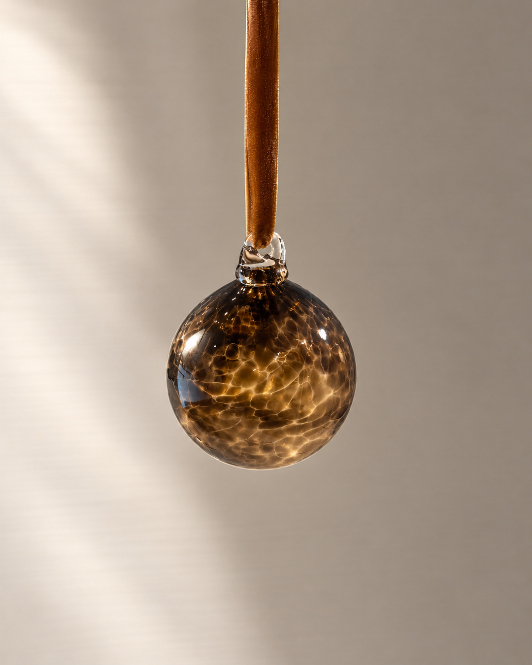 Miniature Smoky Brown Glass Bauble hanging from a velvet ribbon
