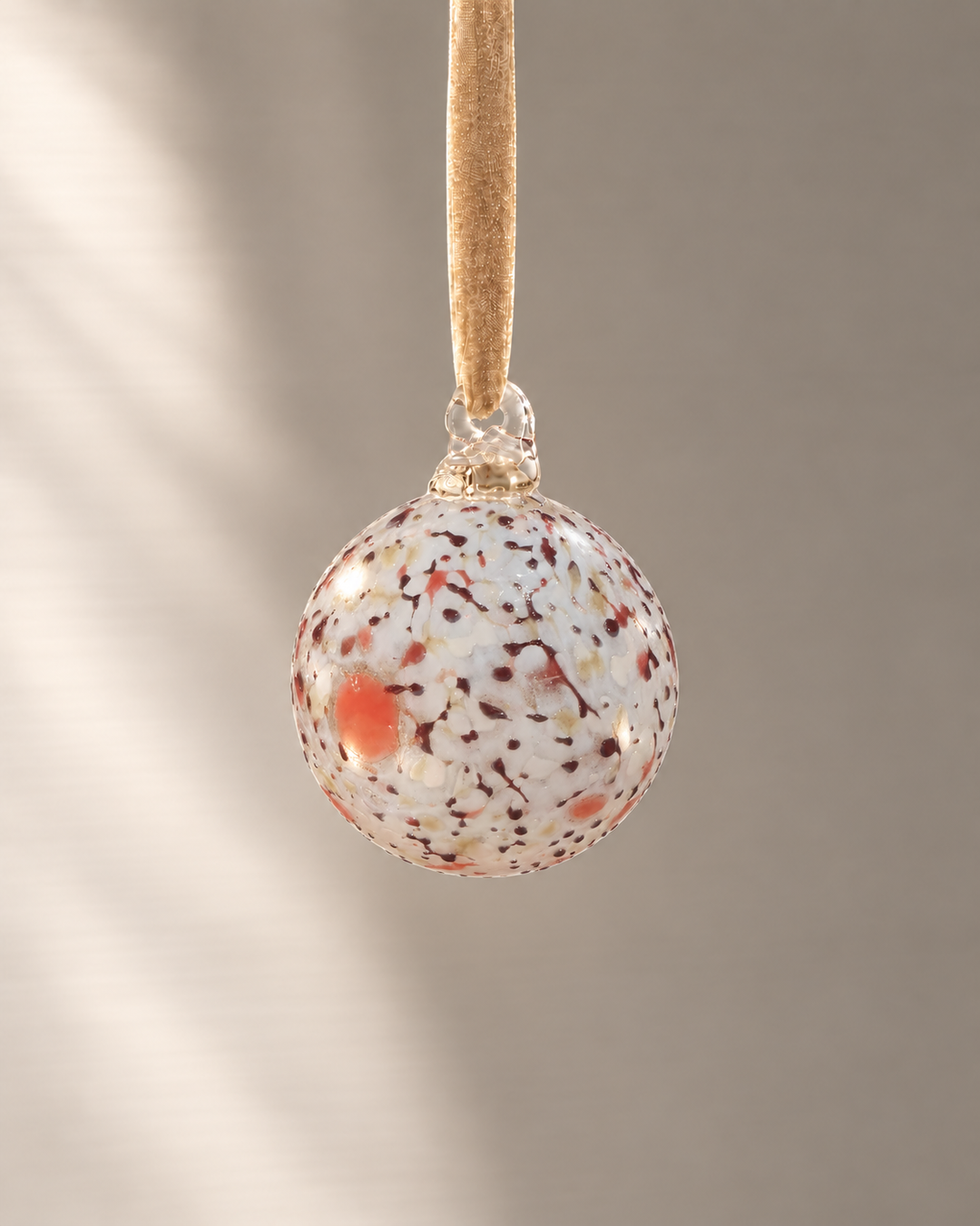 Miniature Opal Speckle Glass Bauble hanging from a velvet ribbon