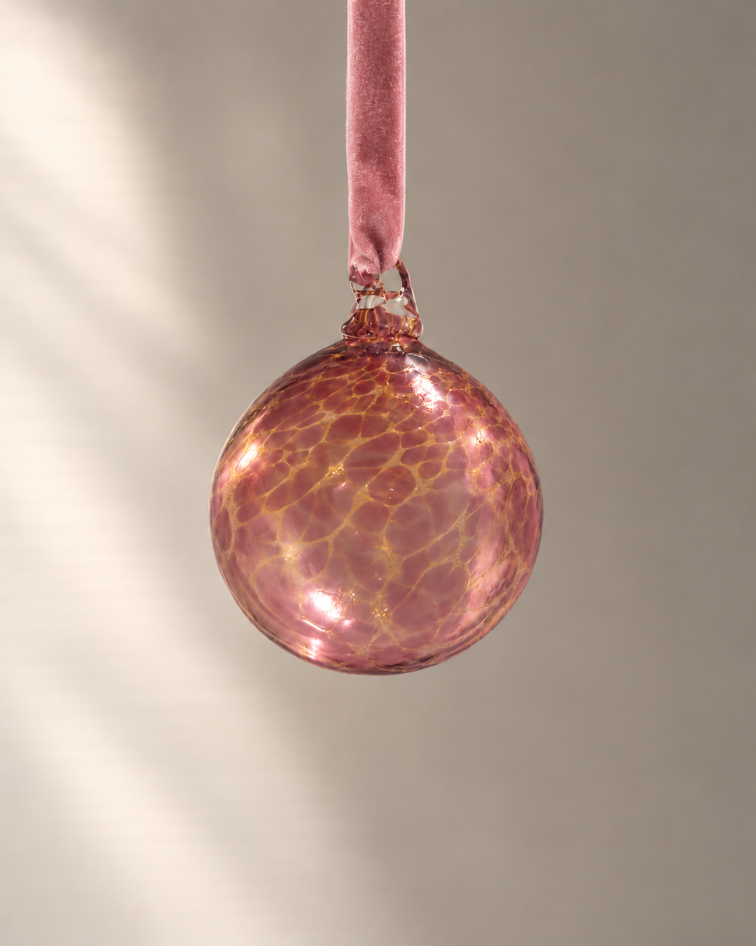 Rose & Gold Glass Bauble hanging from a velvet ribbon