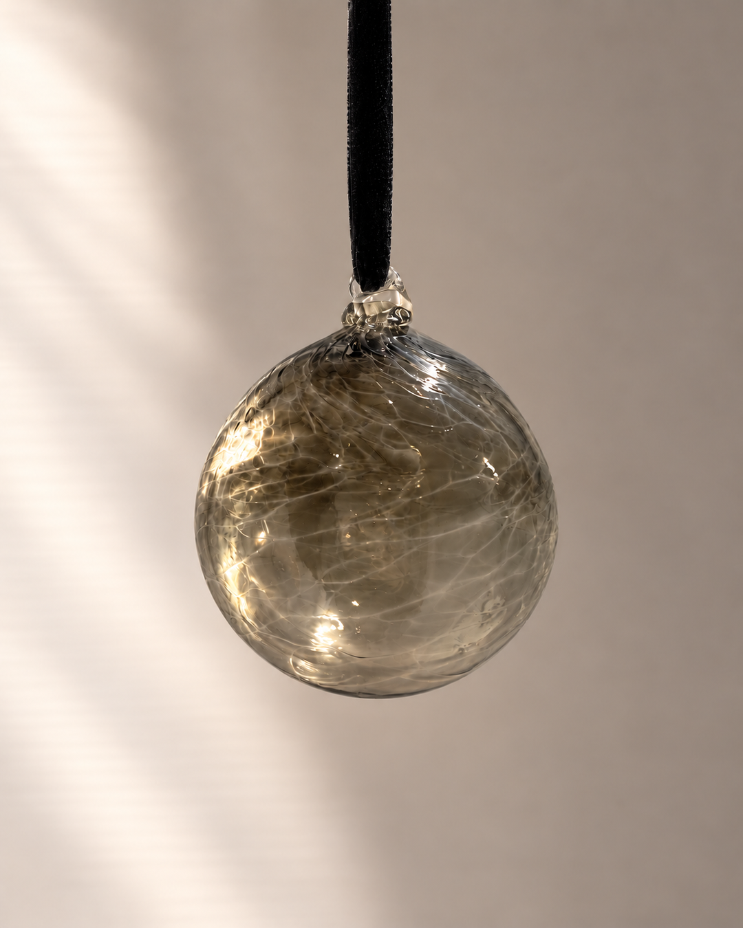 Smoke Grey Glass Bauble hanging from a velvet ribbon