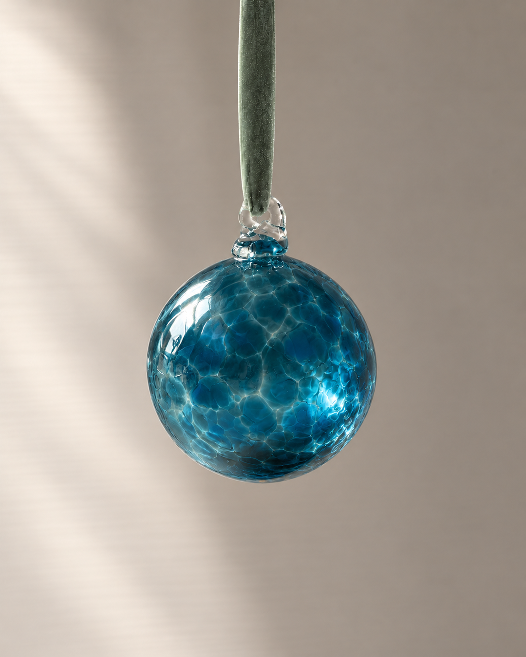 Smoke Teal Glass Bauble hanging from a velvet ribbon