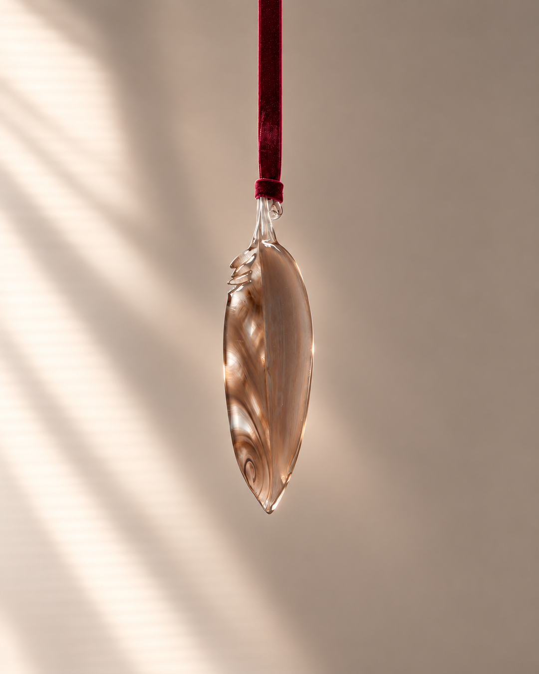 Smoky Brown Glass Feather hanging on velvet ribbon