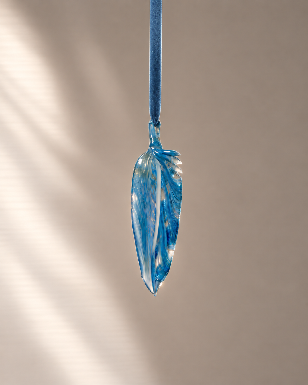 Denim Blue Glass Feather hanging on velvet ribbon