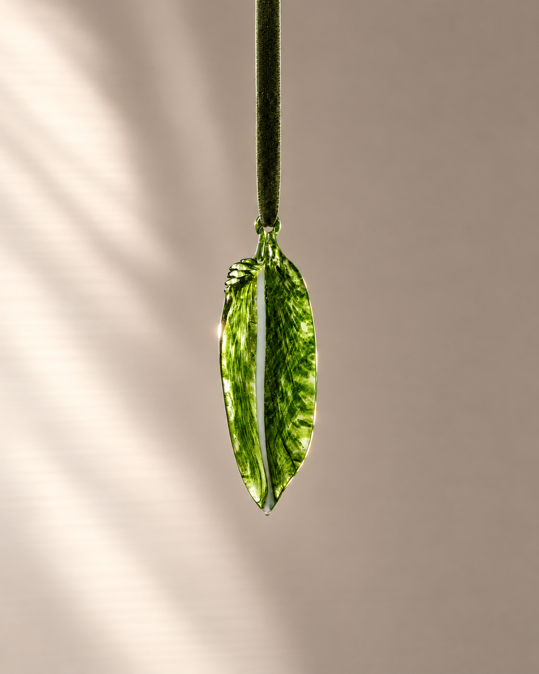 Green Glass Feather hanging on velvet ribbon