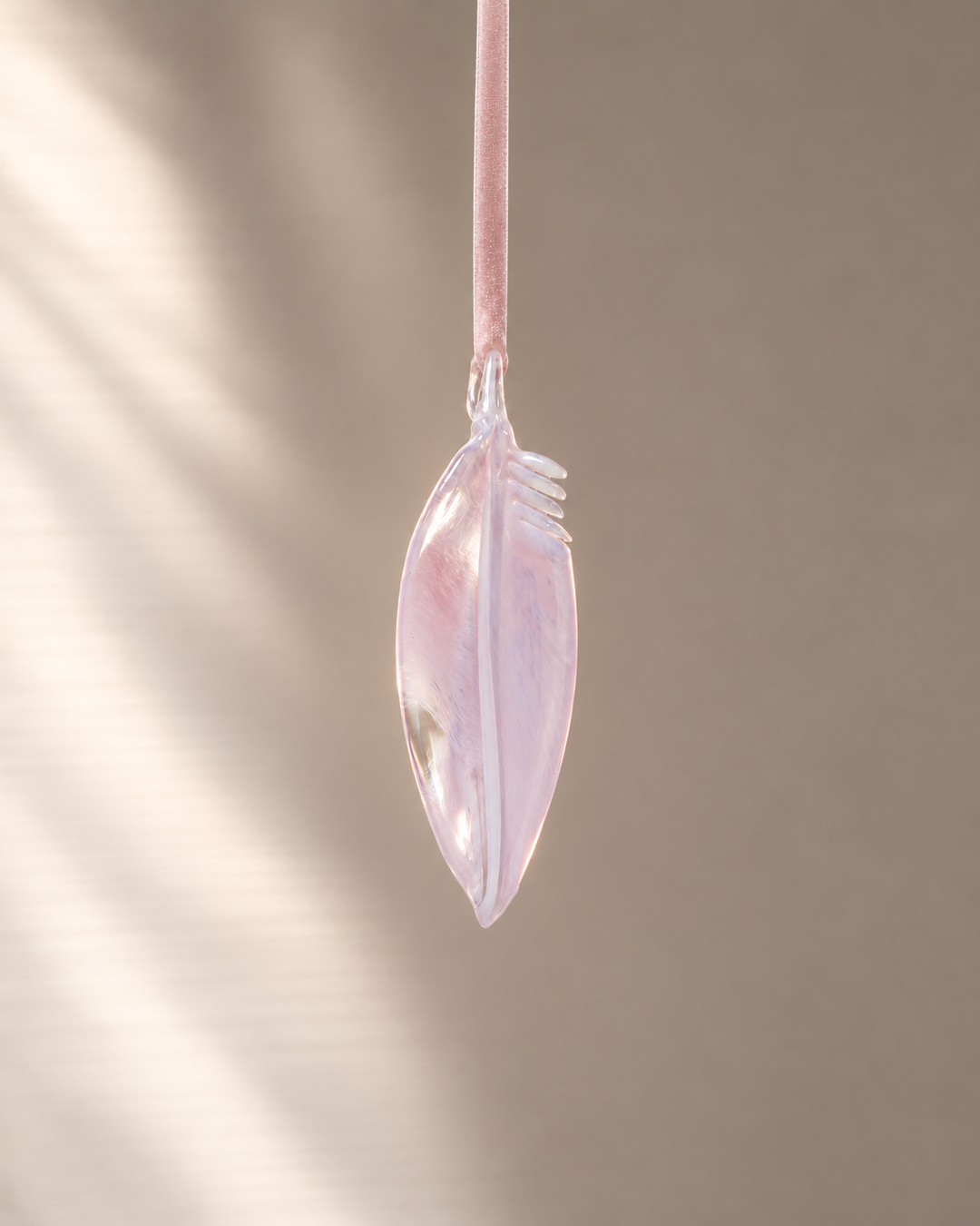 Pale Pink Glass Feather hanging on velvet ribbon