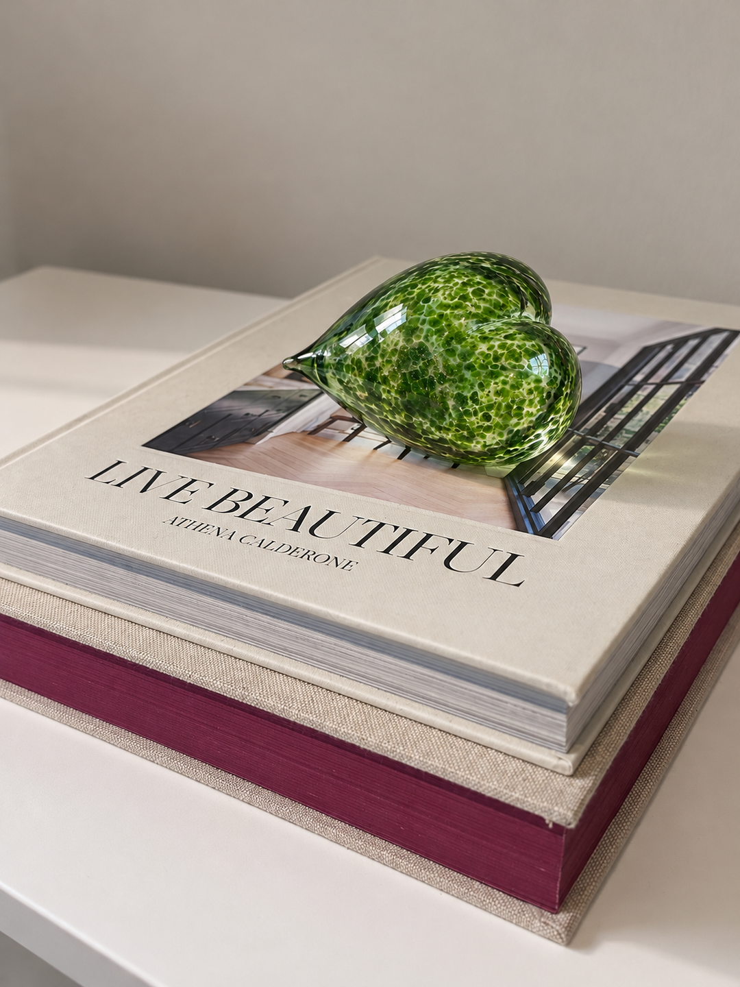 Shimmering Moss Love Heart paperweight — side view on Live Beautiful book