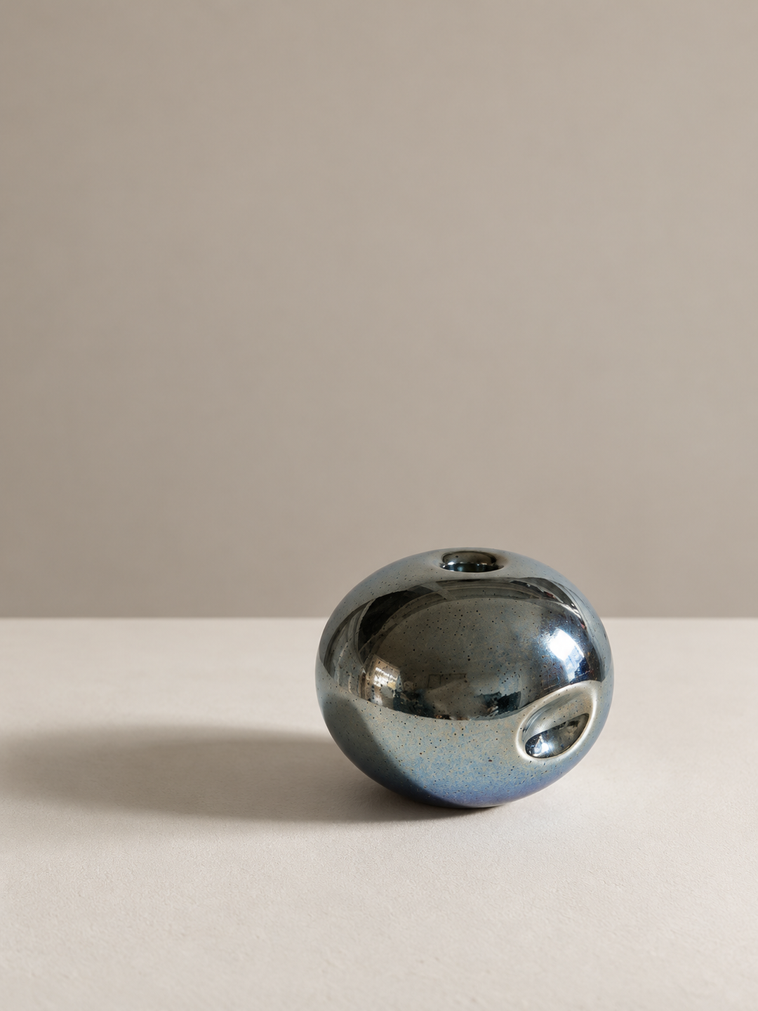 Metallic blue-silver candlestick holder with its distinctive side dimple