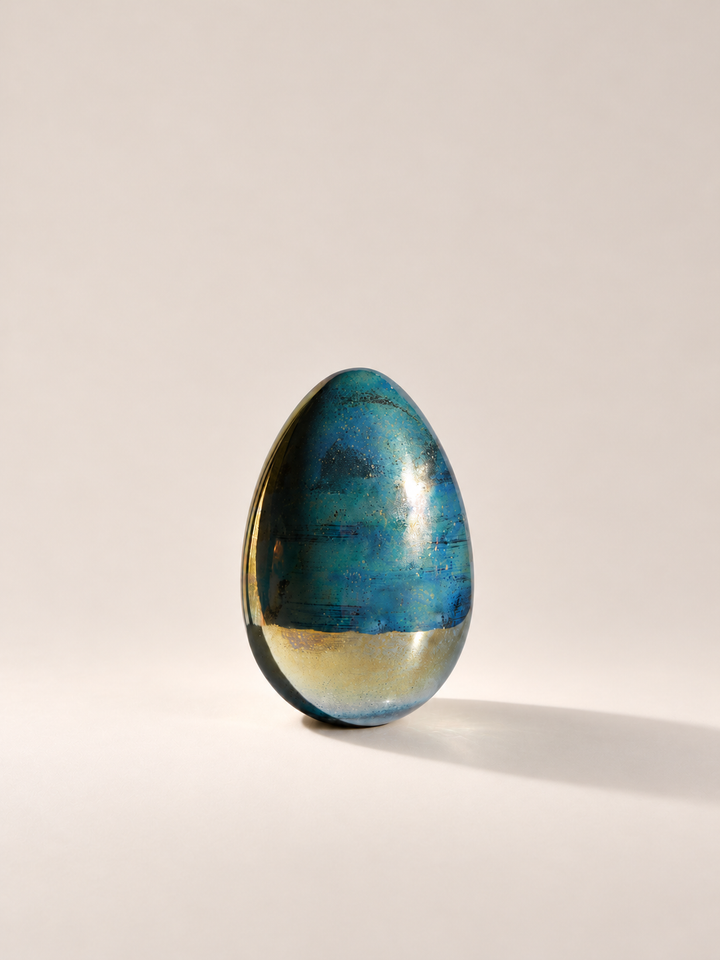 Metallic egg paperweight with spacious studio framing
